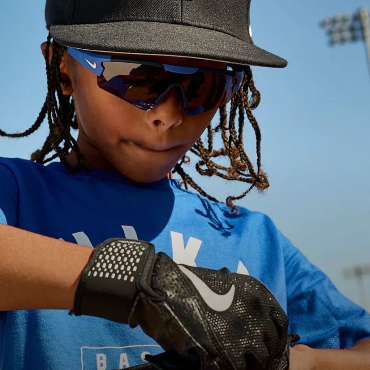 Young athlete wearing Nike sunglasses playing baseball.